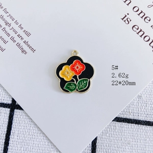 Close-up of a floral alloy enamel pendant with red and yellow flowers for DIY jewelry