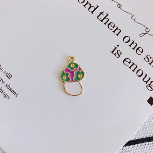 Detail of DIY mushroom pendant with colorful enamel dots and golden metallic frame