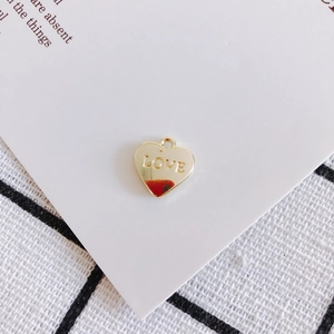 Dettaglio di un ciondolo LOVE dorato a forma di cuore con anello per la creazione di gioielli