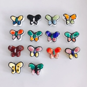 Flat lay of colorful handmade ceramic butterfly beads for DIY jewelry making accessories
