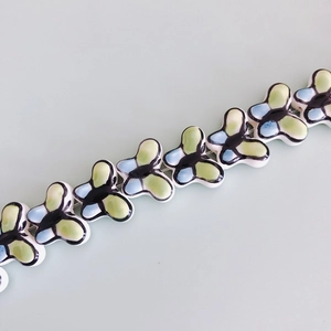 Macro view of butterfly ceramic beads with soft blue and green hand-painted glaze