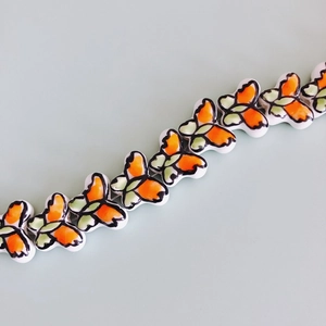 Close-up of colorful butterfly ceramic beads with glazed finish for DIY jewelry crafting