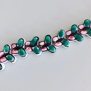 Close-up of colorful butterfly ceramic beads with hand-painted patterns for DIY jewelry