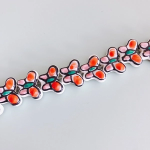 Macro shot of colorful hand-painted butterfly ceramic beads for DIY jewelry making