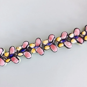 Macro shot of colorful hand-painted ceramic butterfly beads for DIY jewelry making