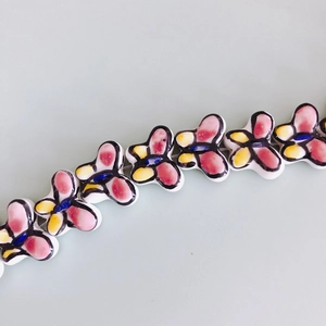 Detailed view of colorful butterfly ceramic beads with hand-painted patterns for DIY jewelry
