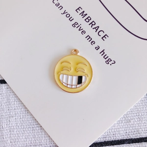 Dettaglio del ciondolo emoji in smalto giallo con bordo dorato per accessori gioielli DIY