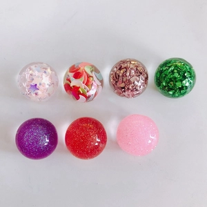 Détail de cabochons en résine avec paillettes étoiles, lunes et feuilles métalliques