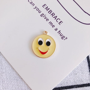 Dettaglio del ciondolo emoji giallo sorridente con gancio per creazione gioielli fai-da-te