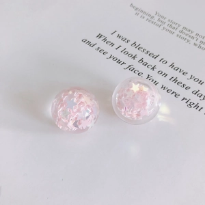 Détail de breloques sphériques en résine rose à paillettes pour accessoires DIY