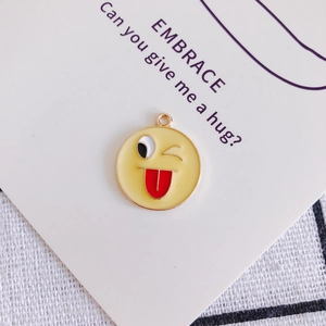 Vista macro di un ciondolo emoji in smalto con anello in metallo per gioielli fai-da-te