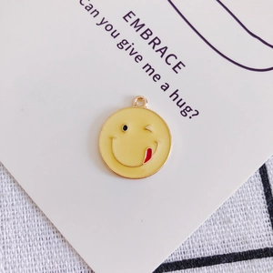 Dettaglio di un ciondolo emoji giallo con occhiolino per gioielli fai-da-te