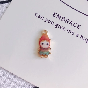 Détail d'un pendentif en alliage de poupée de dessin animé avec cape rouge et boucle métal