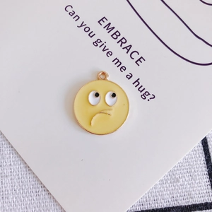 Vista macro di un divertente ciondolo emoji giallo per accessori gioielli fai da te