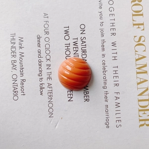 Macro detail of a bright orange resin bead with vertical ridges for DIY shoe charms