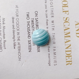 Close-up of light blue resin button with spiral wavy texture for DIY shoe accessories