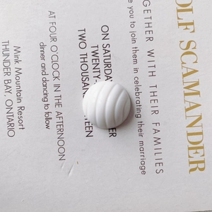 Macro detail of a white resin bead with carved spiral pattern for DIY shoe charms