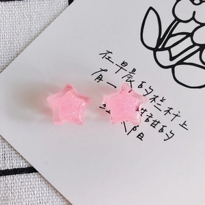 Close-up of pink star-shaped resin charms with shimmering glitter for DIY jewelry making