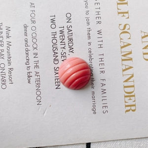 Detailed macro view of a pink round decorative bead with spiral texture for DIY accessories
