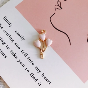 Close-up of pink enamel heart balloon pendants for DIY jewelry making accessories