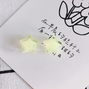Detailed macro view of yellow-green resin star charms with glitter for DIY jewelry making