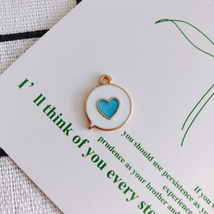 Detailed view of enamel heart pendant on decorative card for DIY jewelry making