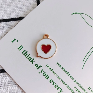Macro shot of white enamel heart charm with gold rim on a minimalist display card