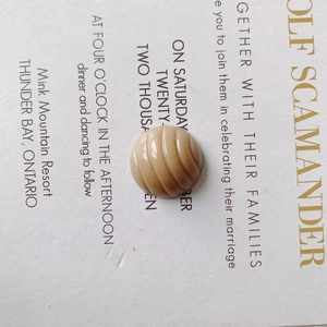 Macro detail of round beige button with spiral texture on elegant printed background
