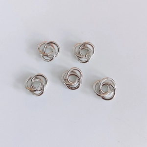 Detalle macro de cinco círculos triples entrelazados en plata pulida para joyas DIY