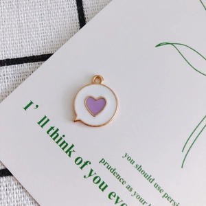 Detailed view of heart-shaped charm with white enamel finish and purple heart center