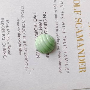 Macro shot of light green striped round charms for DIY shoe accessories and phone cases