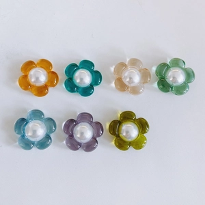 Macro-opname van 7 kleurrijke acrylhars bloembedeltjes met parels voor DIY-haarsieraden