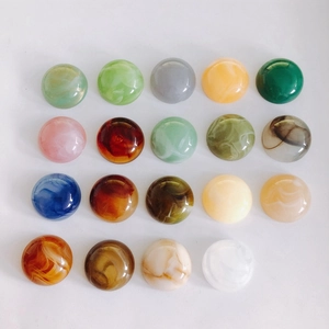 Detailed macro view of flat resin beads with marble textures and vibrant colors