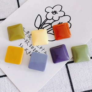 Colorful square resin charms for DIY crafts and phone cases on checkered background