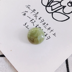 Macro shot of grass green marbled round flat bead for DIY shoes and phone cases