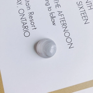 Macro detail of gray-purple flat bead with natural white marble texture for DIY jewelry