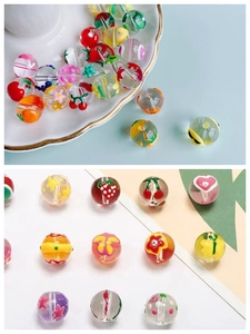 Gros plan de perles en verre peintes à la main avec fleurs et fruits pour bijoux DIY