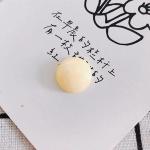 Macro shot of a cream-colored translucent resin bead for DIY jewelry and phone cases