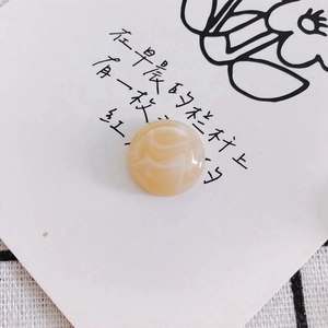 Macro detail of round yellow resin bead with marble texture for DIY accessory crafts