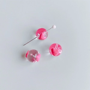 Vue détaillée de perles en verre avec cœurs roses pour la création de bijoux DIY