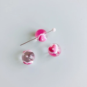Gros plan de perles en verre à motifs de cœur avec tige métallique pour bijoux DIY