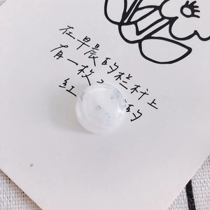 Close-up of translucent white marble effect bead on a decorative floral card