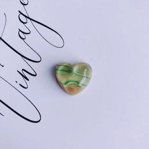Detail of vintage oil painting heart-shaped resin accessory with green stripes
