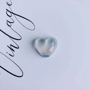 Macro shot of blue and white oil painting style heart-shaped resin accessory with vintage text