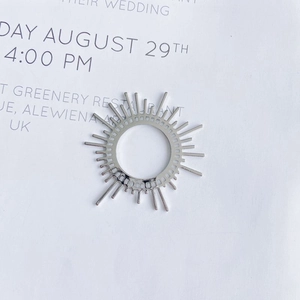 Macro shot of silver sunburst pendant charm with geometric radial lines for DIY jewelry