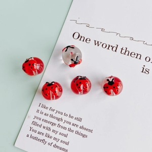 Dettaglio di perline di vetro a coccinella DIY con fori per creare gioielli
