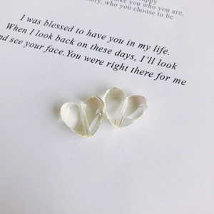 Close-up of transparent light yellow heart beads with holes for DIY jewelry making