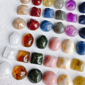 Flat lay of colorful marble pattern resin charms in square and round geometric shapes