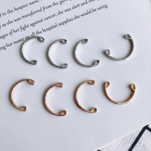 Close-up of C-shaped gold and silver plated jewelry connectors for DIY crafting and assembly