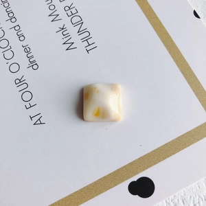 Close-up of square yellow marble resin charms for DIY jewelry and phone case making